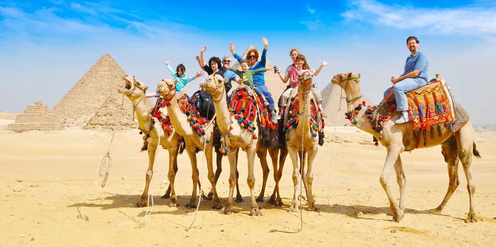 Family enjoying a camel ride at the Giza Pyramids in Egypt